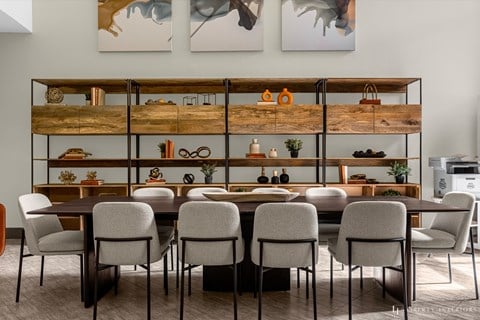 a dining room with a table and chairs in front of a wall with shelves